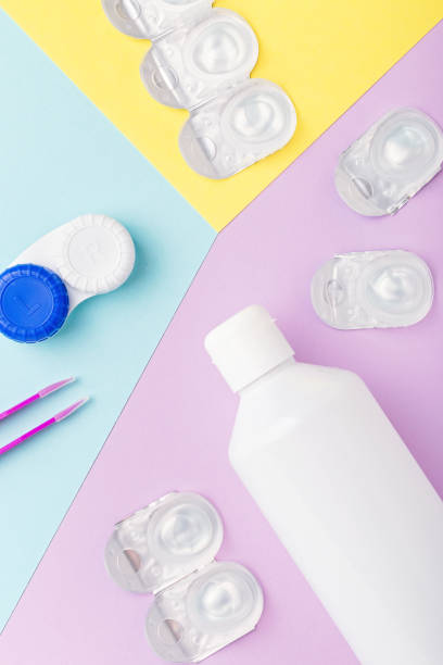 istock Contact lens kit with bottle of lens solution, case, tweezer on multicolor background, flat lay, top view 1280643973