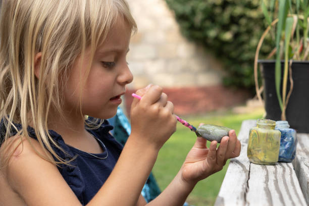 istock Little girl painting a stone 1280647525