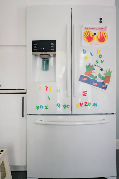 réfrigérateur blanc dans la cuisine moderne avec l’artisanat d’enfant - lettre magnétique photos et images de collection
