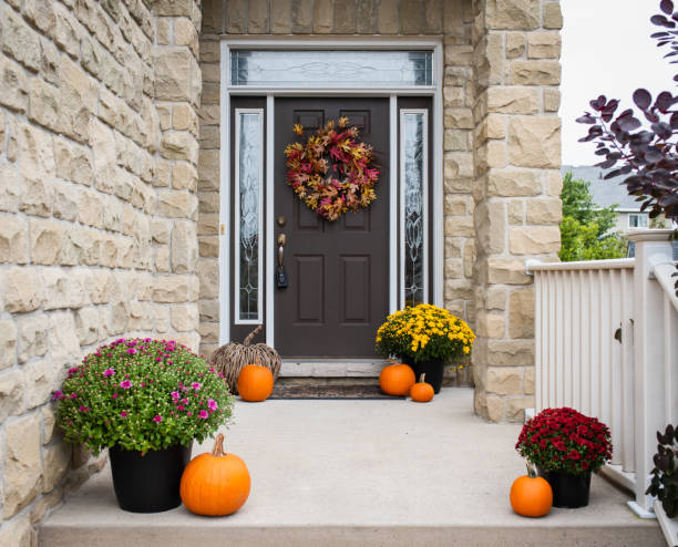 porte d’entrée de la maison décorée pour l’automne avec des fleurs et des citrouilles. - loggia photos et images de collection