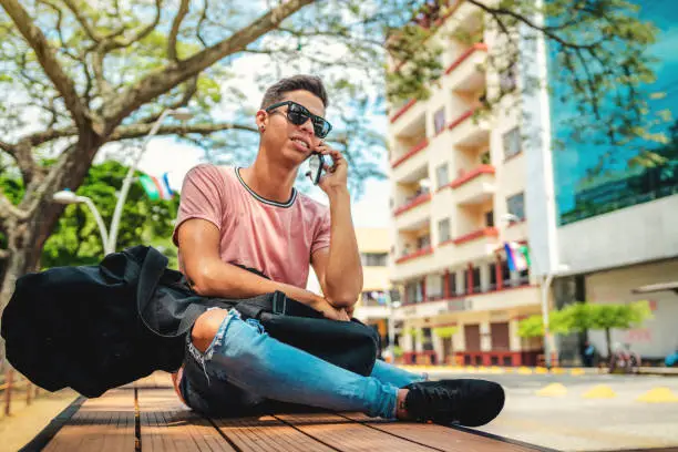 Hipster Young Man Talking On The Phone While Sitting In The StreetShot of hipster young man talking on the phone while sitting in the street