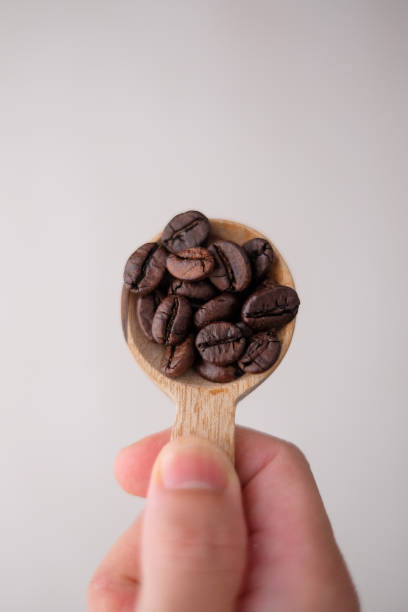 istock Wooden spoon filled with coffee beans 1280664770