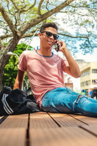Hipster Young Man Talking On The Phone While Sitting In The StreetShot of hipster young man talking on the phone while sitting in the street