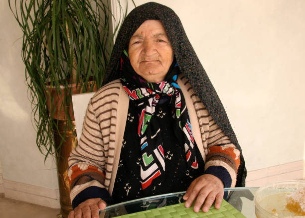 Senior Turkish woman wearing a headscarf looking at camera, smiling portrait