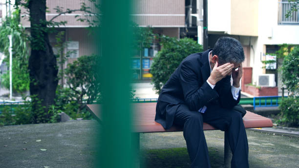 depressiver asiatischer geschäftsmann sitzt auf einer bank. - chinese ethnicity ethnic senior adult business stock-fotos und bilder