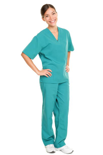 Nurse standing isolated. Young multiracial nurse or medical doctor standing isolated in full length wearing blue scrubs Nurse standing isolated. Young multiracial nurse or medical doctor standing isolated in full length wearing blue scrubs medical scrubs stock pictures, royalty-free photos & images