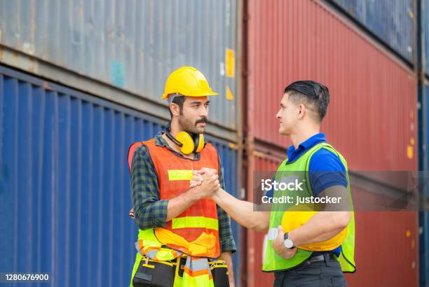 Engineer And Worker Soul Brother Handshake Thumb Clasp Handshake Or Homie Handshake With Blurred Containers Cargo Background Success And Teamwork Concept Stock Photo - Download Image Now