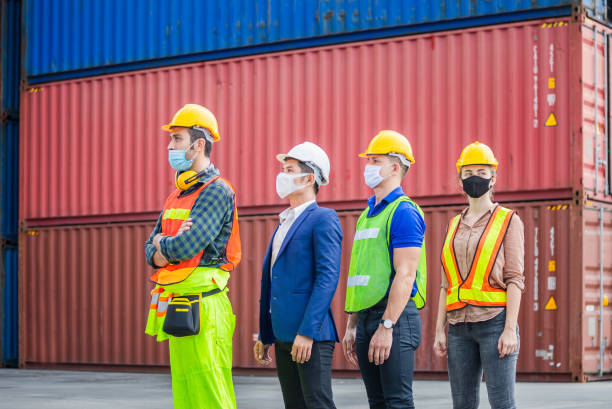 istock Factory worker and engineer team wearing protection face mask against coronavirus ( COVID-19 ), Business people team standing in line at cargo containers 1280676904