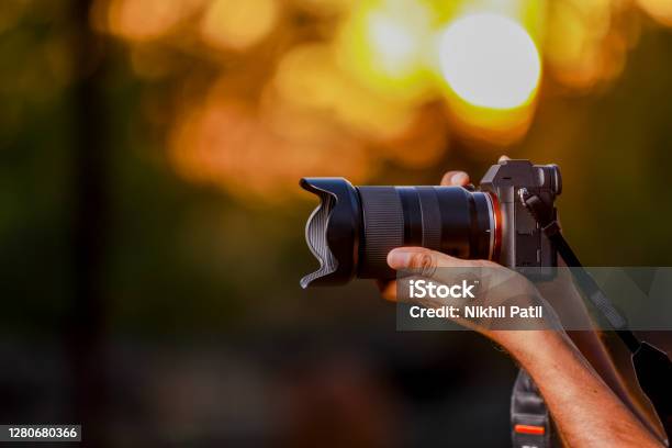 Jalgaon Maharashtra India May 4 2020 Closeup Of A Black Camera Holding By Photographers Hand With Sunset Background Stock Photo - Download Image Now