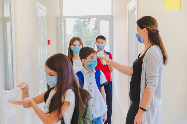 istock Little girl disinfecting hands while entering school. 1280685518