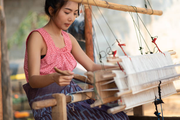 istock Young women weaving with traditional Thai weaving machine 1280687266