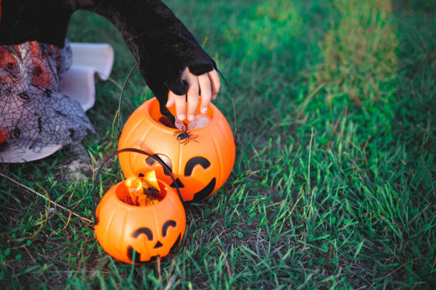 istock a child's hand reaches for candy in a pumpkin-shaped candy basket 1280688487