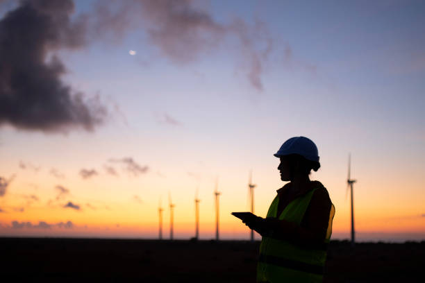 erneuerbare energiesysteme. strom-wartungsingenieur arbeitet auf dem feld in einem windturbinenkraftwerk in der dämmerung. - industry dusk night sustainable resources stock-fotos und bilder