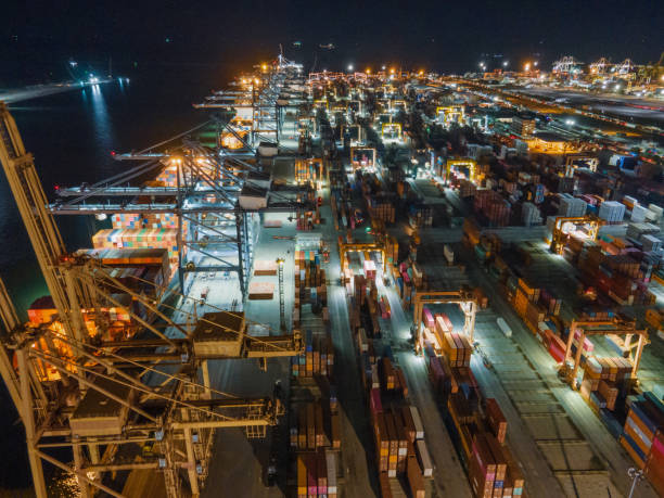 istock Drone point of view Logistics and import,export Container Cargo ship in asia working for e-commerce business Shot by drone crane bridge in shipyard at sunset , logistic import export and transport industry background 1280696236
