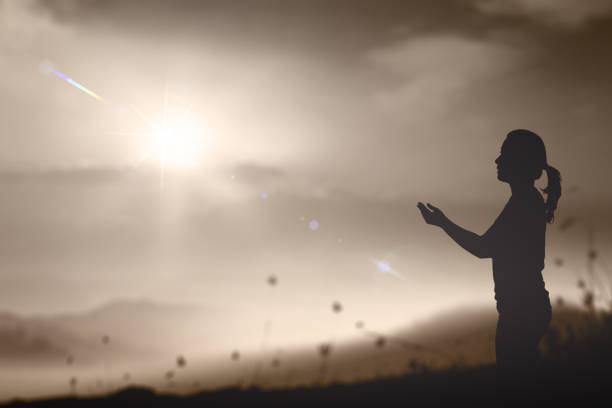 Silhouette prayer woman pray to God on autumn sunset background