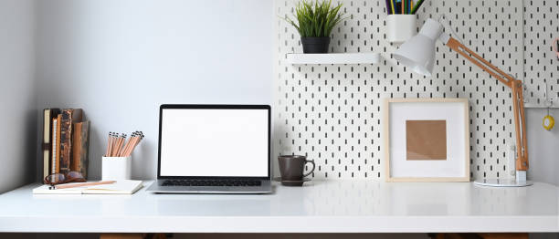 istock Mockup blank screen laptop and office supplies on white desk. 1280698464