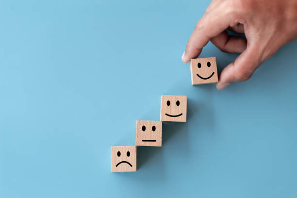 istock Close up top view customer hand choose smiley face on wood cube, Service rating, satisfaction concept. 1280698762