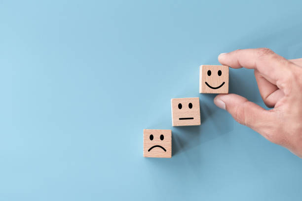 istock Close up top view customer hand choose smiley face on wood cube, Service rating, satisfaction concept. 1280698775