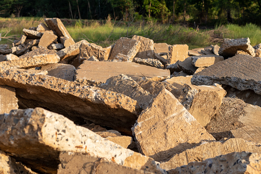 Close-up view of the large concrete debris left on the countryside with sunlight during the daytime.