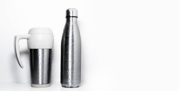 istock Thermo mug and reusable steel bottle, sprayed with water, isolated on white background with copy space. 1280701885