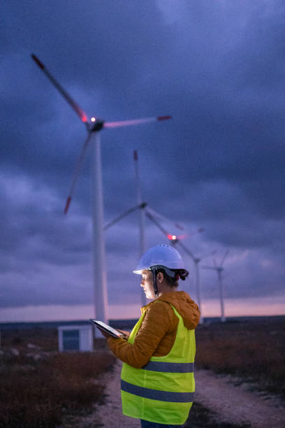 системы возобновляемых источников энергии. инженер по техническому обслуживанию электроэнергии, работающий на поле на ветротурбинной эле - industry dusk night sustainable resources стоковые фото и изображения