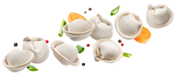 Raw dumplings, frozen russian pelmeni isolated on white background Falling raw dumplings, frozen homemade russian pelmeni isolated on white background russian pelmeni stock pictures, royalty-free photos & images