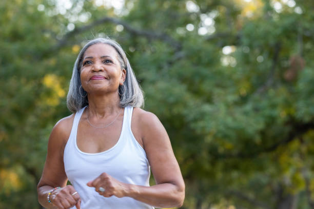 starsza kobieta biegająca w publicznym parku - senior adult relaxation exercise healthy lifestyle exercising zdjęcia i obrazy z banku zdjęć