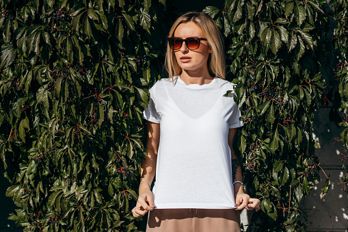 Stylish blonde girl wearing white t-shirt and glasses