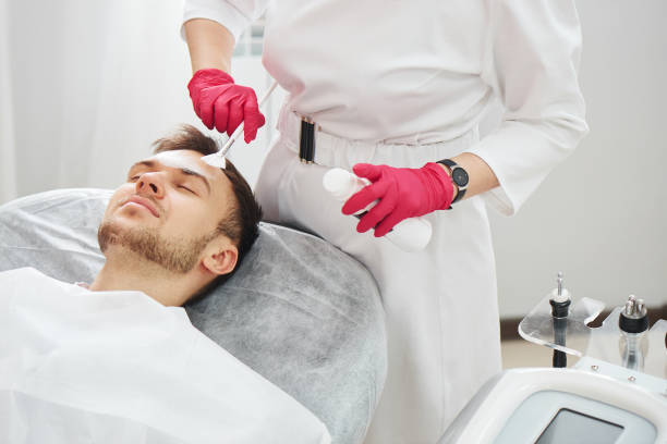 Handsome Caucasian young man at cosmetology procedures in beauty parlor at the beautician. Male dermatologist skin care, closeup face mask Handsome Caucasian young man at cosmetology procedures in beauty parlor at the beautician. Male dermatologist skin care, closeup face mask metrosexual stock pictures, royalty-free photos & images