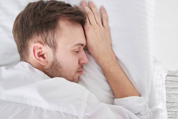 istock Close-up portrait of sleeping brunette man on white pillow 1280707614