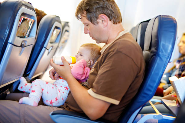 istock Father holding his baby daughter during flight on airplane going on vacations 1280707718