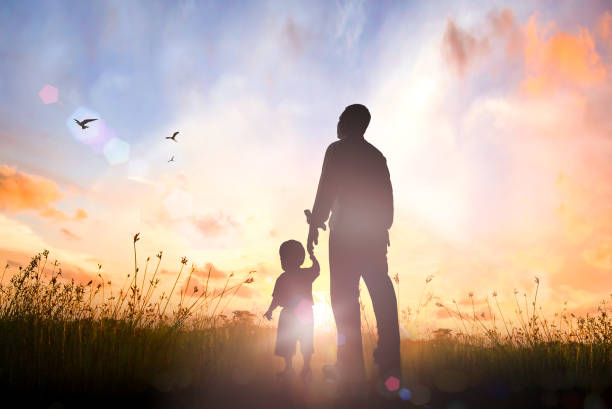 Father day concept Son hand holding dad finger on meadow sunrise background fathers day fathers love day stock pictures, royalty-free photos & images