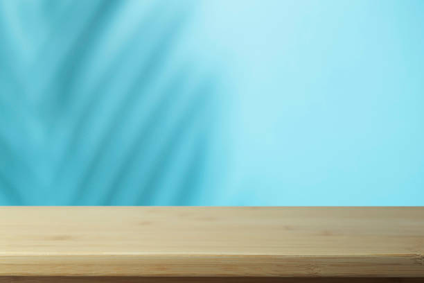istock Flat lay  background. Minimal  background with shadows of palms and empty wooden table. 1280713036