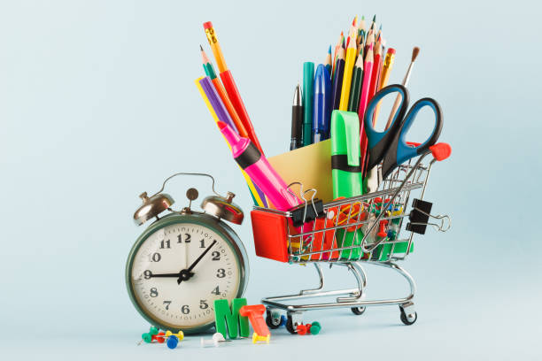 istock Shopping cart with different stationery, light blue background 1280715320
