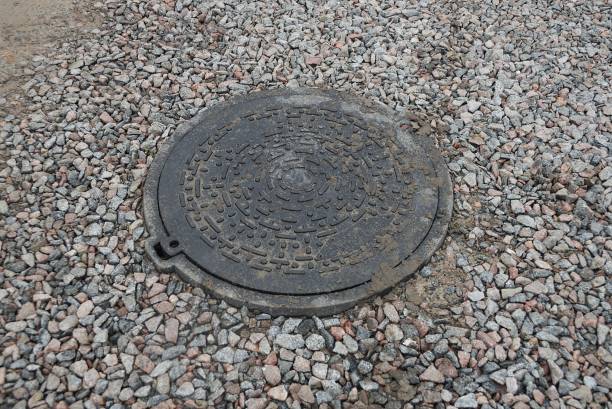 istock one black iron sewer manhole among gray fine rubble 1280717721