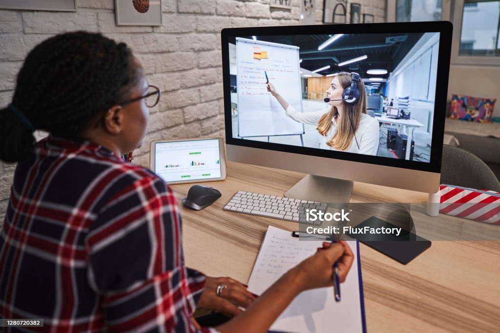 While watching online tutorial about business improvement focused woman taking down notes so she can expand her business knowledge Diligent young woman using her free time during COVID-19 lockdown to learn some new thing and expand her knowledge for her future business 25-29 Years Stock Photo