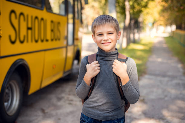 istock Cheerful young boy with a backpack returning home by school bus 1280722675