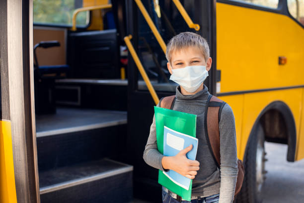 istock Elementary school learner in facial medical mask going to a bus after the classes. 1280722682