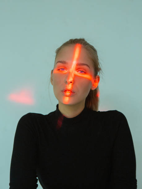 istock Cool young girl with cross shaped red light on her face in studio 1280723548