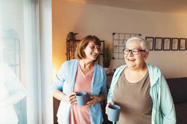 istock Senior women at home, drinking coffee and looking through the window 1280725554