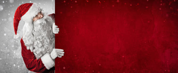istock Santa Claus Showing Something On a Red Wall 1280728346