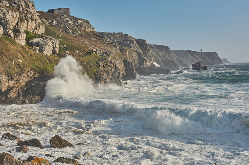 Rough sea at the coastline in Finistère, France. Big waves breaking on cliffs in Crozon, France.