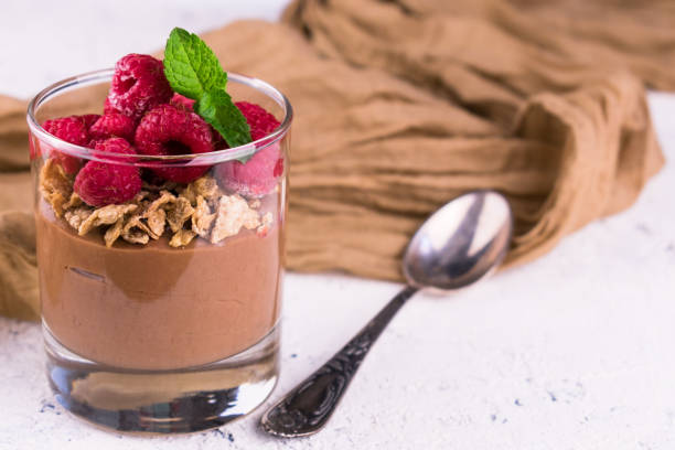 istock Chocolate pudding with raspberries and mint in a glass on a white plate.Copy space. 1280729155