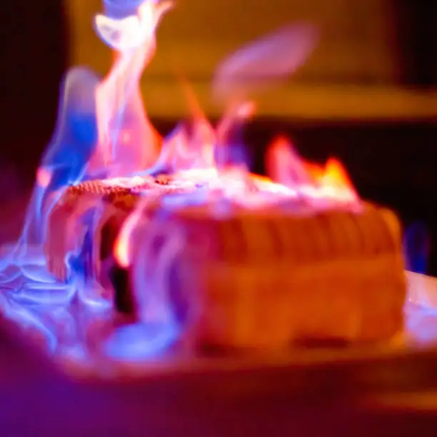 Flambé of a dessert during a party with large flames on the ome