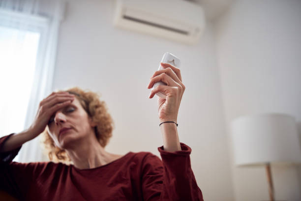 istock Woman with headache using aircondition unit at home. 1280735911
