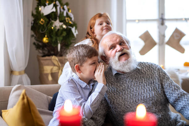 niños pequeños con abuelo mayor en casa en navidad, jugando. - whispering grandparent child grandfather fotografías e imágenes de stock