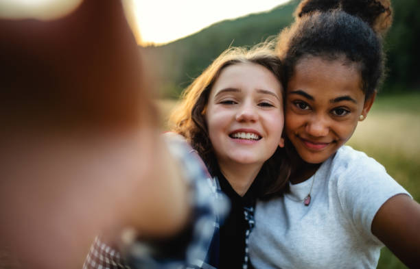 vue avant des jeunes filles adolescentes amis à l’extérieur dans la nature, prenant le selfie. - pre adolescent child little girls friendship child photos et images de collection