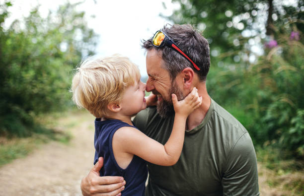 istock Father with small son hiking outdoors in summer nature, having fun. 1280738223
