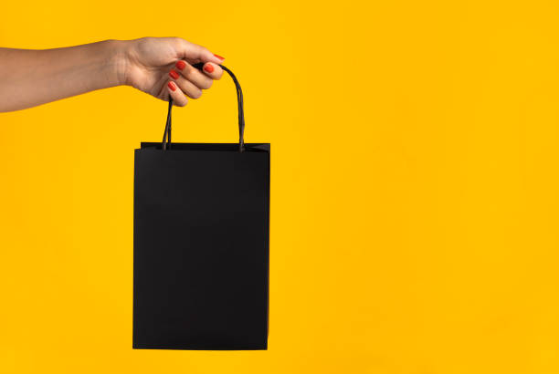 istock Woman holding black shopping bag 1280741452