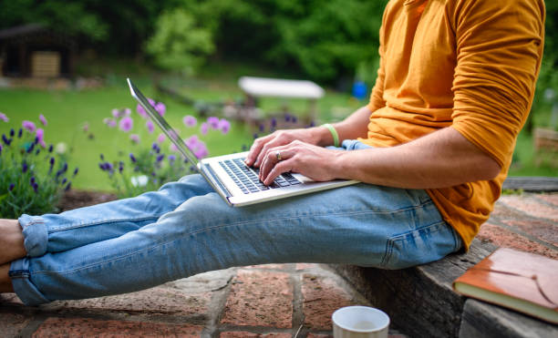 istock Unrecognizable man with laptop working outdoors in garden, home office concept. 1280741646